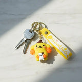 3D PVC Figure Keychain - Pompompurin De Hello Kitty - Pompompurin Holding Macaroon